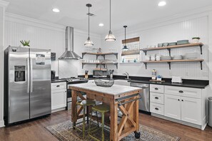 A modern kitchen with white cabinetry, stainless steel appliances, and wooden accents. - 🌴 Vitamin Sea | 4BR Beach Retreat | Pool + Beach Shuttle 🏖️ (Destin)