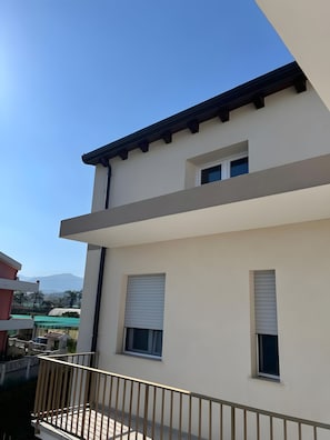 A modern two-story building with a balcony and a view of the surrounding area.