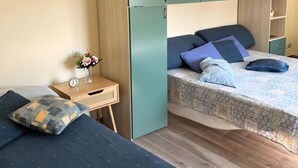 Ein Schlafzimmer mit einem Bett, einem Nachttisch, einer Kommode und einem Kleiderschrank.