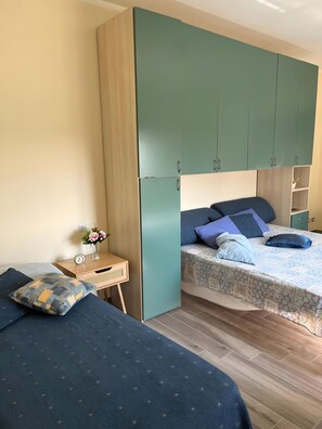 Ein Schlafzimmer mit einem Bett, einem Nachttisch, einer Kommode und einem Kleiderschrank.