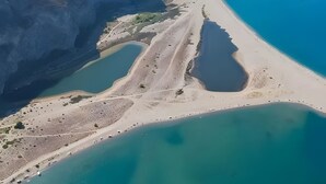 Vista aérea de una zona costera con playa, acantilados y una masa de agua.