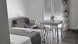 Un dormitorio con cama, una mesa y una silla.