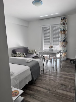 A bedroom with a bed, a table, and a chair. - Casa Del Giglio Apartment (Vigliatore)
