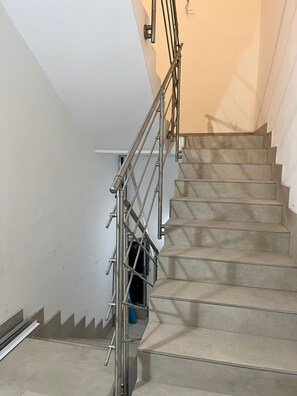 A staircase with metal railings and beige steps.