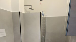 Un baño moderno con inodoro, bidé, ducha y lavamanos.