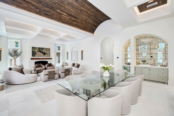 A spacious living room with a glass-top coffee table, comfortable seating, and a fireplace. - Just B | Private Pool | Pickleball Court | Home Gym (Inlet Beach)