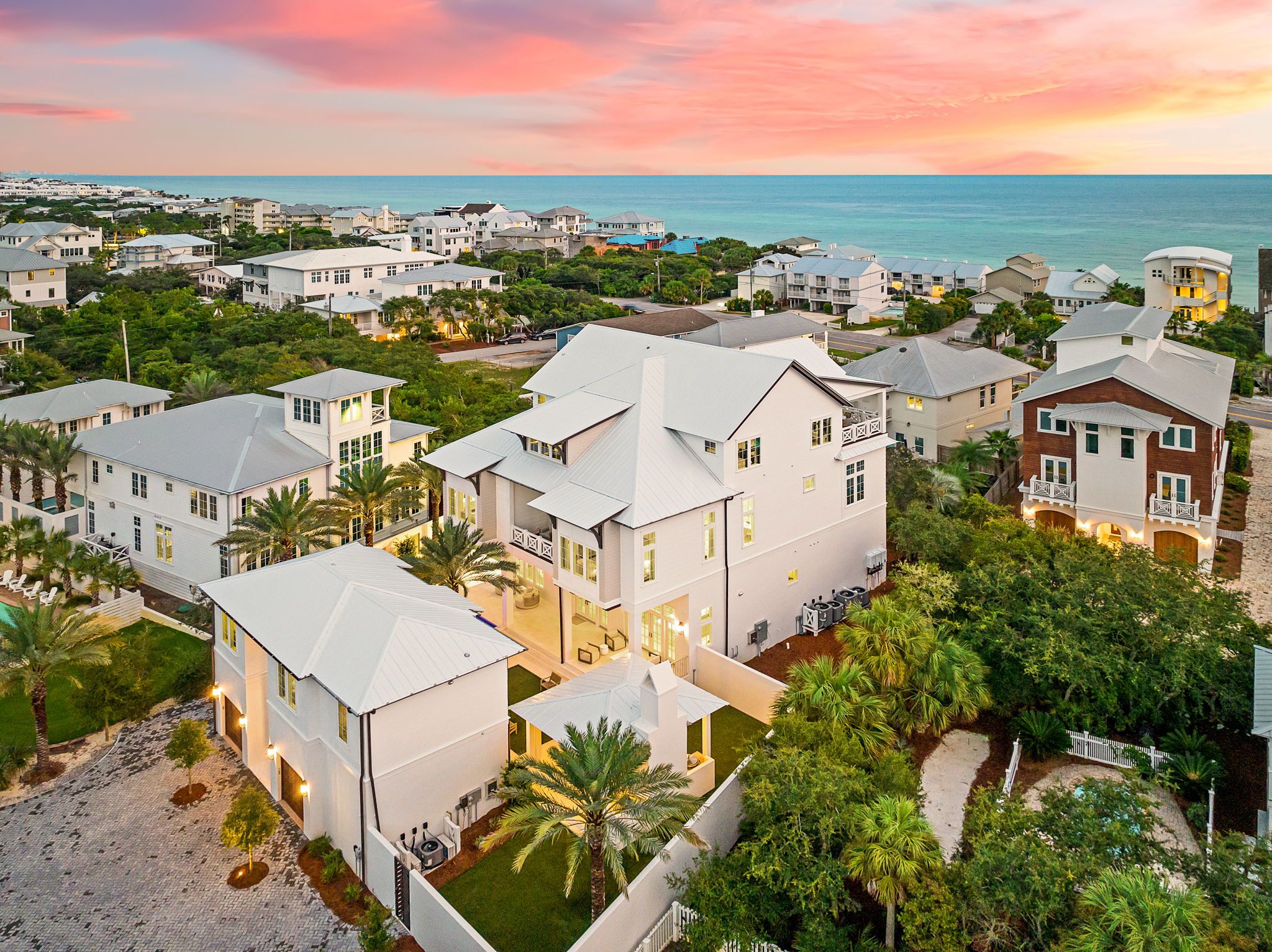 A coastal residential area with multiple houses, some with balconies, and a view of the ocean.