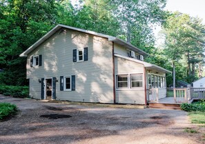 A two-story house with a front porch, a garage, and a driveway.