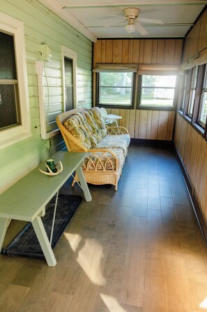 A room with a wicker sofa, a bench, and a ceiling fan. - Cabin with hot tub, internet, path to the creek, 4 acres in peaceful Landisburg (Landisburg)