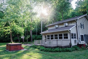 A house with a deck, surrounded by trees, and a hot tub in the yard. - Cabin with hot tub, internet, path to the creek, 4 acres in peaceful Landisburg (Landisburg)