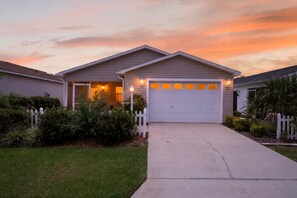 A residential house with a garage, a driveway, and a well-maintained lawn. - 2472 Z3A Village of Lynnhaven (The Villages)