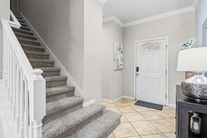 A staircase with carpeted steps and white railings leading to a door with a decorative glass panel. - Resort Escape Near Disney: Poolside Family Fun! (Kissimmee)
