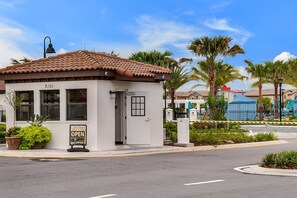 A small, single-story building with a tiled roof, a door, and windows. There is a sign on the door that reads "OPEN". - Resort Escape Near Disney: Poolside Family Fun! (Kissimmee)