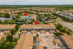 A residential area with multiple houses, a swimming pool, and a road. - Resort Escape Near Disney: Poolside Family Fun! (Kissimmee)