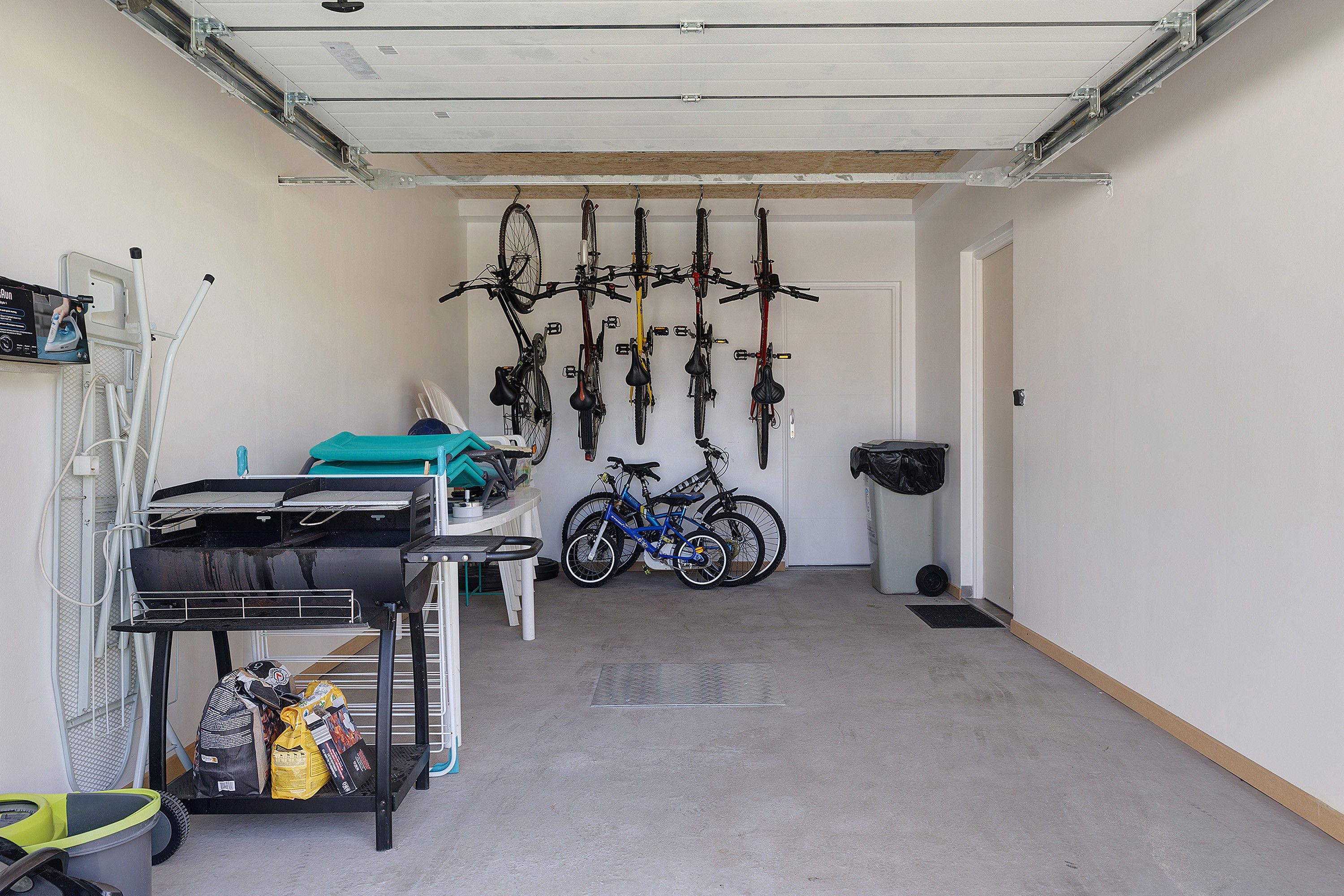 Eine Garage mit Fahrrädern und einem Grill.