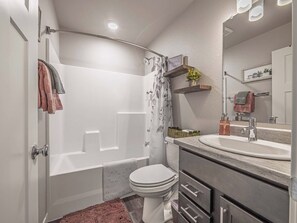 Un baño moderno con ducha, inodoro y tocador.