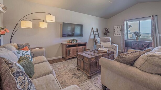 A cozy living room with a sofa set, a coffee table, a TV, and a window with curtains. - Family-Friendly 3BR | Dream Kids’ Room & Garage (Rapid City)