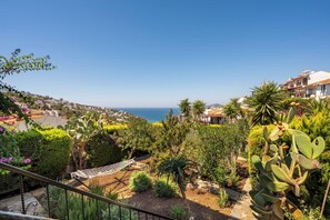A residential area with a view of the sea, featuring houses with balconies, a hammock, and various plants. - Denize Sıfır Villa. Özel Plaj&Doğal Havuz.Bodrum (Milas)