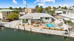 Une propriété située au bord de l’eau, dotée d’une piscine, d’un espace extérieur aménagé et d’un patio couvert.