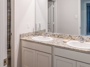 A bathroom with two sinks, a mirror, and a door. - Woodridge - Entire Home (Porter)