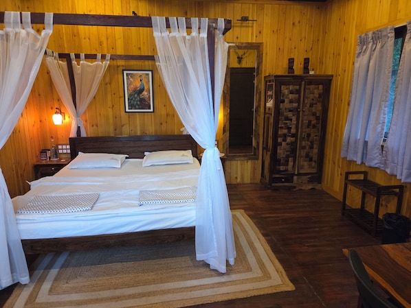Una cama con dosel, un armario de madera, un espejo y un cuadro en la pared.
