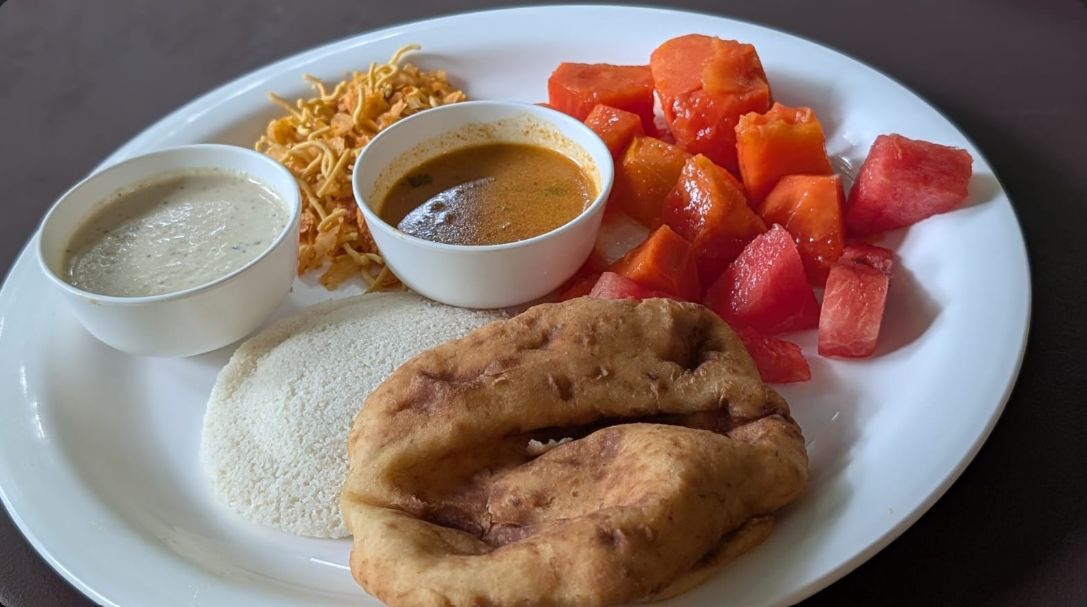Un plato con un pan plano, un tazón de salsa, un tazón de fideos y verduras en cubos.