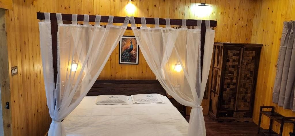 Una habitación con cama bajo un dosel, paredes de madera, un cuadro en la pared y un armario.