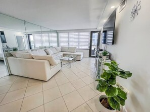 A modern living room with a sofa set, a coffee table, and a potted plant. - Charming 2BR/2BA Oceanfront Gem, Miami Beach (Miami Beach)