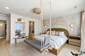 A bedroom with a four-poster bed, a hanging swing, a nightstand, and a telescope.