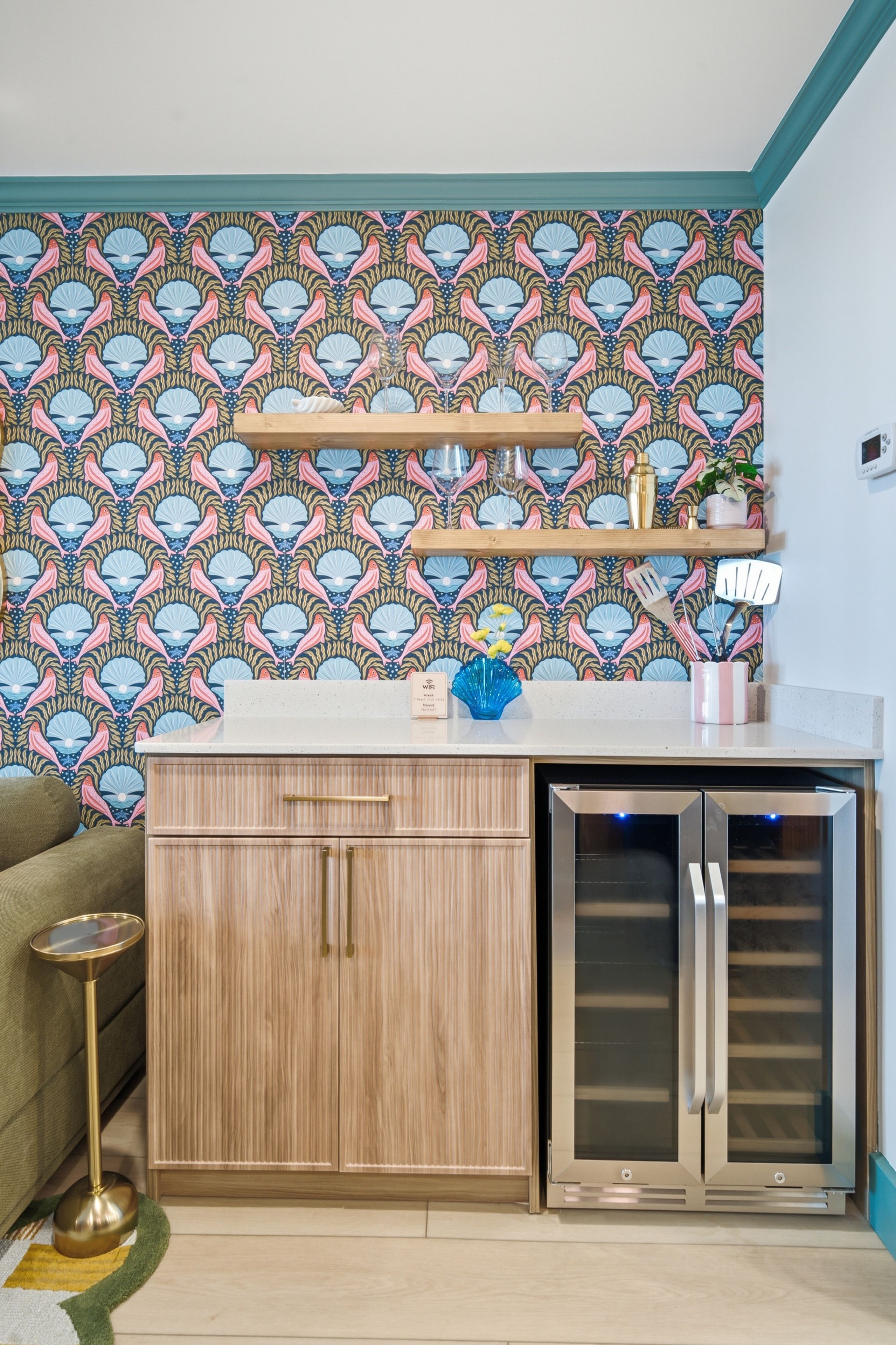 A kitchen with a patterned wallpaper, wooden cabinets, a countertop, and a built-in oven.