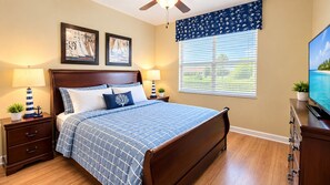 A bedroom with a bed, nightstands, a dresser, a television, and a window with blinds. - 6BR Family Vacation Home Paradise Palms Private Pool Near Disney (Kissimmee)