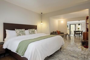 Ein Hotelzimmer mit einem großen Bett, einer Couch, einem Esstisch und einem Stuhl.