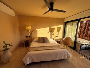 Ein modernes Schlafzimmer mit einem Bett, Nachttischlampen, einem Deckenventilator und einem großen Fenster.