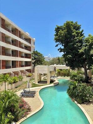 Ein Resort mit Pool, Außenbereich und einem mehrstöckigen Gebäude mit Balkonen.