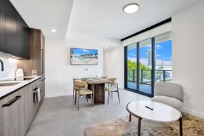 Cozinha moderna com área de refeições, uma ampla janela com vista para a cidade e uma pequena mesa redonda.