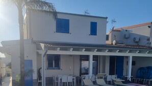 Un bâtiment moderne doté d’une piscine, d’un espace extérieur aménagé et d’un patio couvert.
