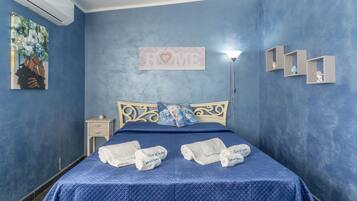 A bedroom with a bed, a nightstand, a wall-mounted shelf, and a painting.