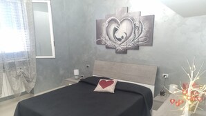 Une chambre à coucher moderne comprenant un lit, une table de chevet, une œuvre d’art murale et une plante décorative.