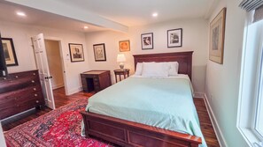 A bedroom with a bed, dresser, nightstand, lamp, and framed pictures on the wall. - Spacious 2 bedroom apartment located minutes from Ithaca, Cornell, Cortland (Groton)