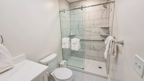 Ein Badezimmer mit Duschkabine, Toilette und Waschbecken.