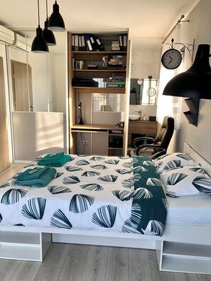 Una camera da letto con un letto, una scrivania e una libreria.