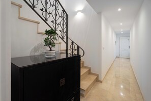 Eine Treppe mit schwarzer Handlauf und einem Blumentopf auf der Zwischenebene.