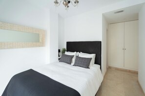 Ein Schlafzimmer mit Bett, Spiegel, Kleiderschrank und einer Chandelier.