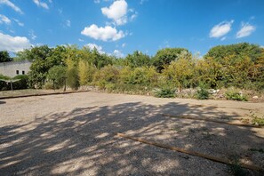 A gravel parking area with trees and a building in the background. - Villa 'L'escale Au Soleil' with Private Pool, Wi-Fi and Air Conditioning (Montauroux)