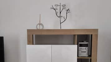 A white cabinet with a wooden top shelf, a small decorative tree, and a Sony audio system on the right.