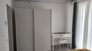 Ein Zimmer mit einem Bett, einem Schreibtisch und einem Kleiderschrank.