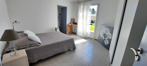 A bedroom with a bed, a desk, a chair, and a painting. - Bed and Breakfast 'Chambre Cézanne' with Mountain View, Shared Pool and Air Conditioning (Saumane de Vaucluse)