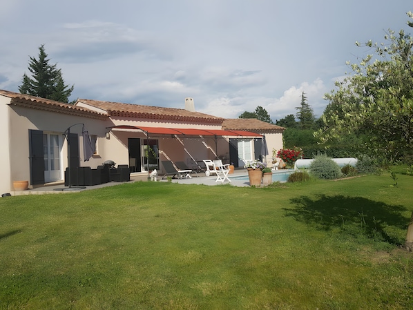 A house with a covered patio, outdoor seating, and a swimming pool. - Bed and Breakfast 'Chambre Modigliani' with Mountain View, Wi-Fi and Air Conditioning (Saumane de Vaucluse)