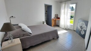 Ein Schlafzimmer mit einem Bett, einem Schreibtisch, einem Stuhl und einem Gemälde.