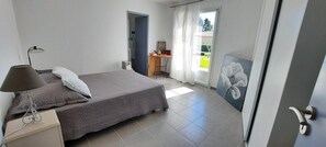 A bedroom with a bed, a desk, a chair, and a painting. - Bed and Breakfast 'Chambre Modigliani' with Mountain View, Wi-Fi and Air Conditioning (Saumane de Vaucluse)